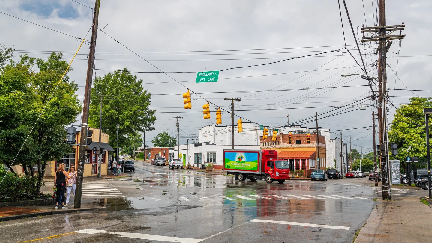 Five Points intersection in East Nashville, with Woodland Street storefronts after rain.