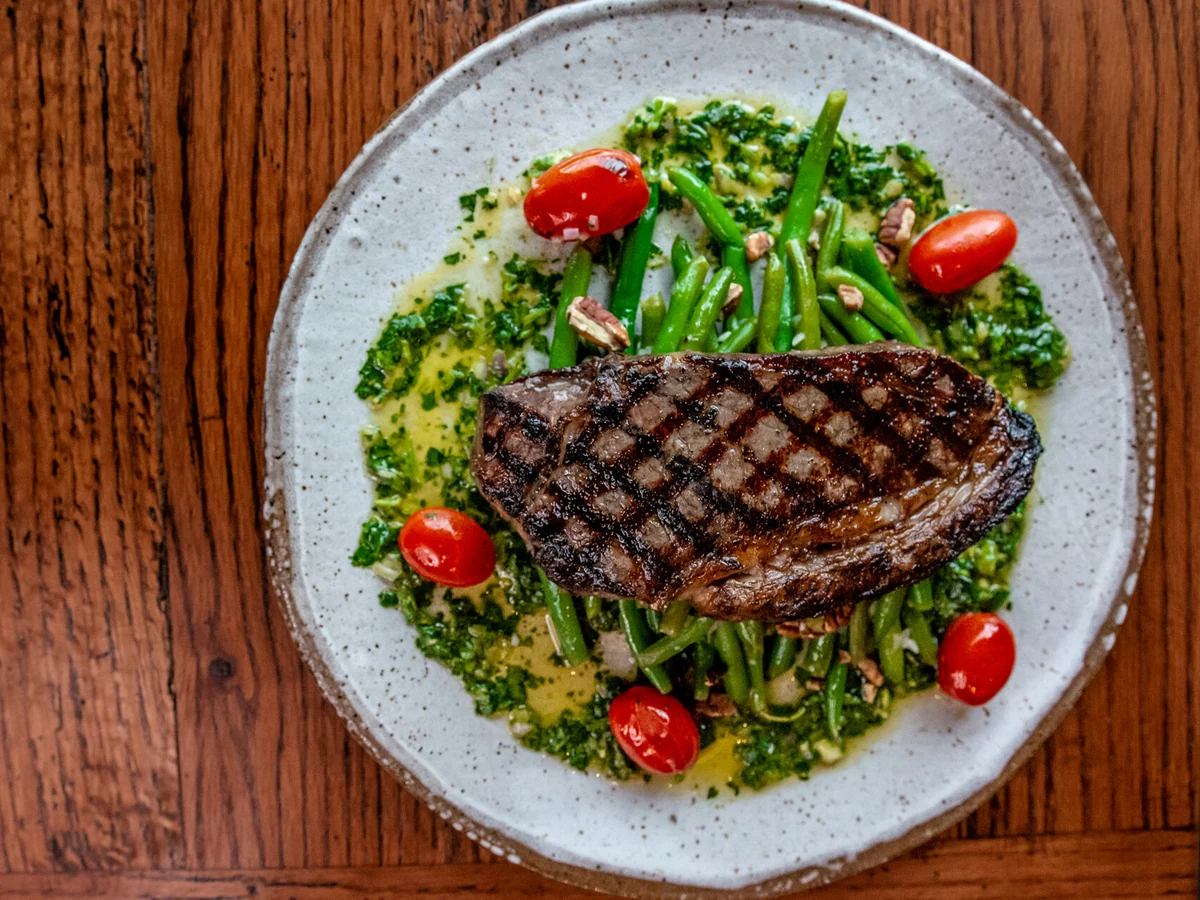 Lockeland Table’s New York strip steak with green beans, tomatoes, and chimichurri.